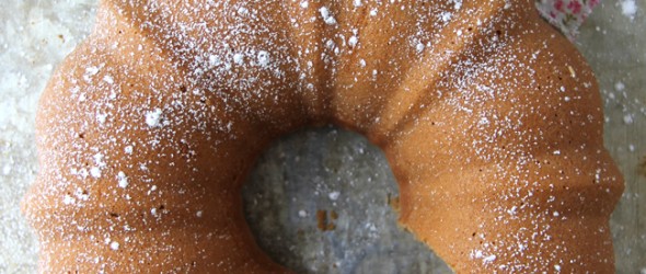 An earl grey tea cake with two slices cut and dusted with icing sugar.