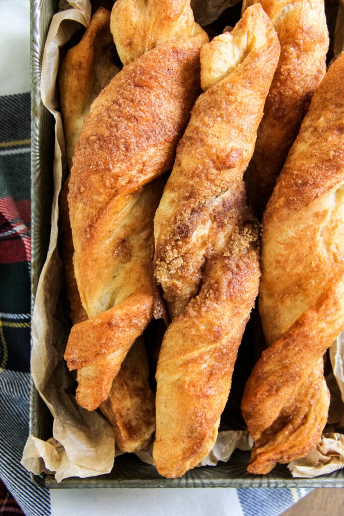 a top down close up image of a pan of cinnamon sugar breadsticks