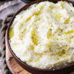 a bowl of leek mashed potatoes drizzled with melted butter