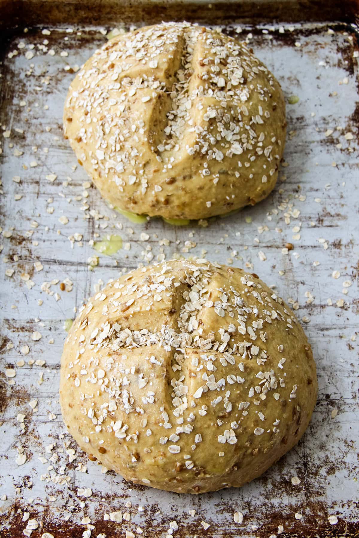 unbaked loaves of Hearty Bread Machine Honey Oat Bread on a baking pan