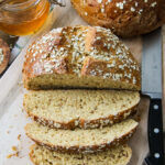 a loaf of Hearty Bread Machine Honey Oat Bread cut into slices