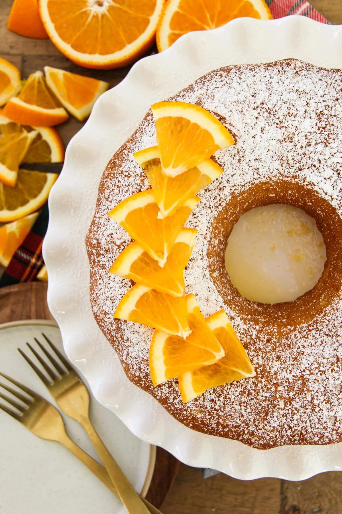a close up of an orange bundt cake with fresh orange slice garnishes