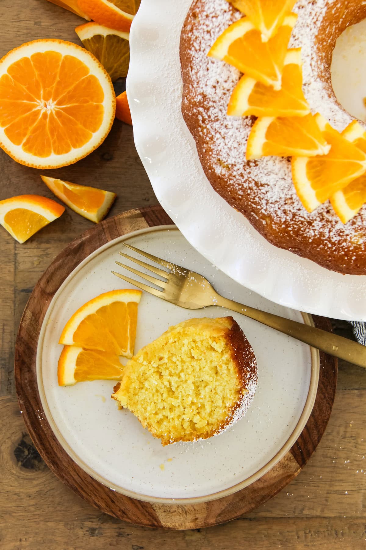 a slice of orange bundt cake next to the cake