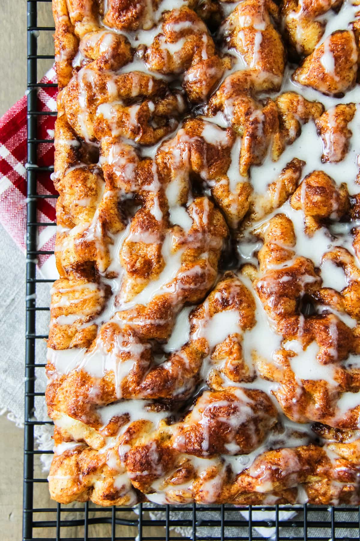 cinnamon roll focaccia with sugar glaze drizzle sitting on a wire cooling rack