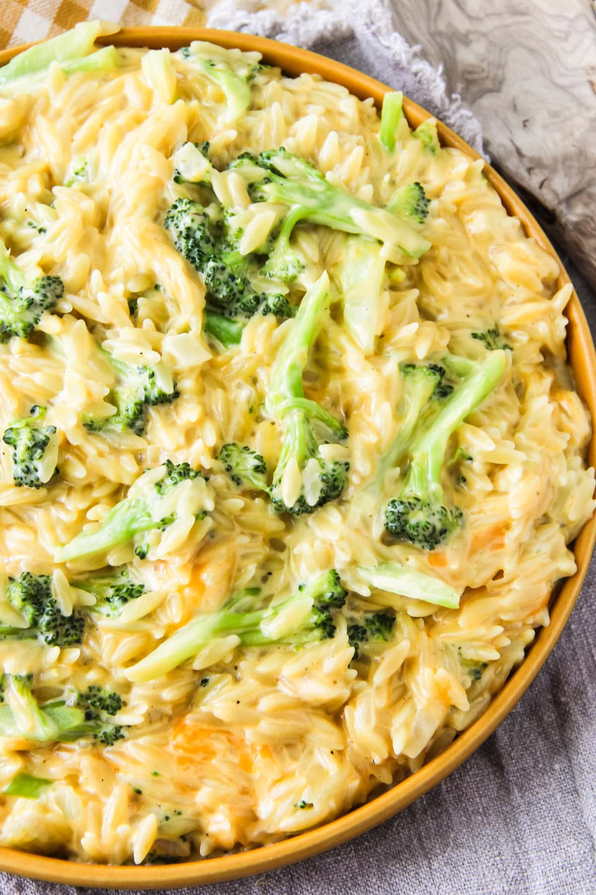 One Pot Cheesy Broccoli Cheddar Orzo in a yellow bowl