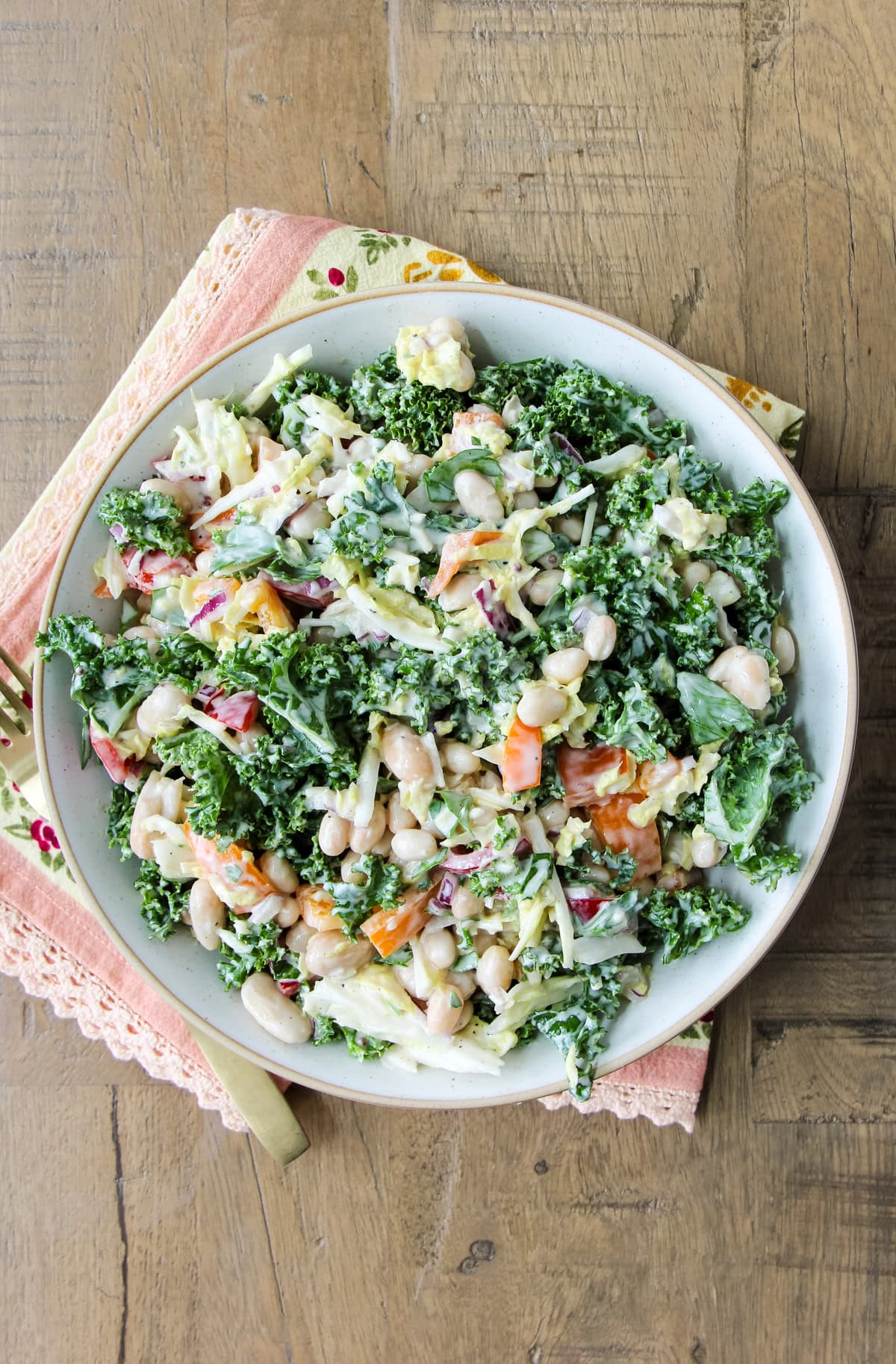 a bowl of Kale and White Bean Salad on a wood table