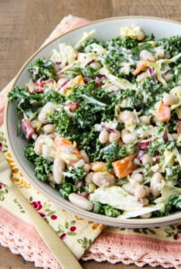 a bowl of Kale and White Bean Salad on a wood table