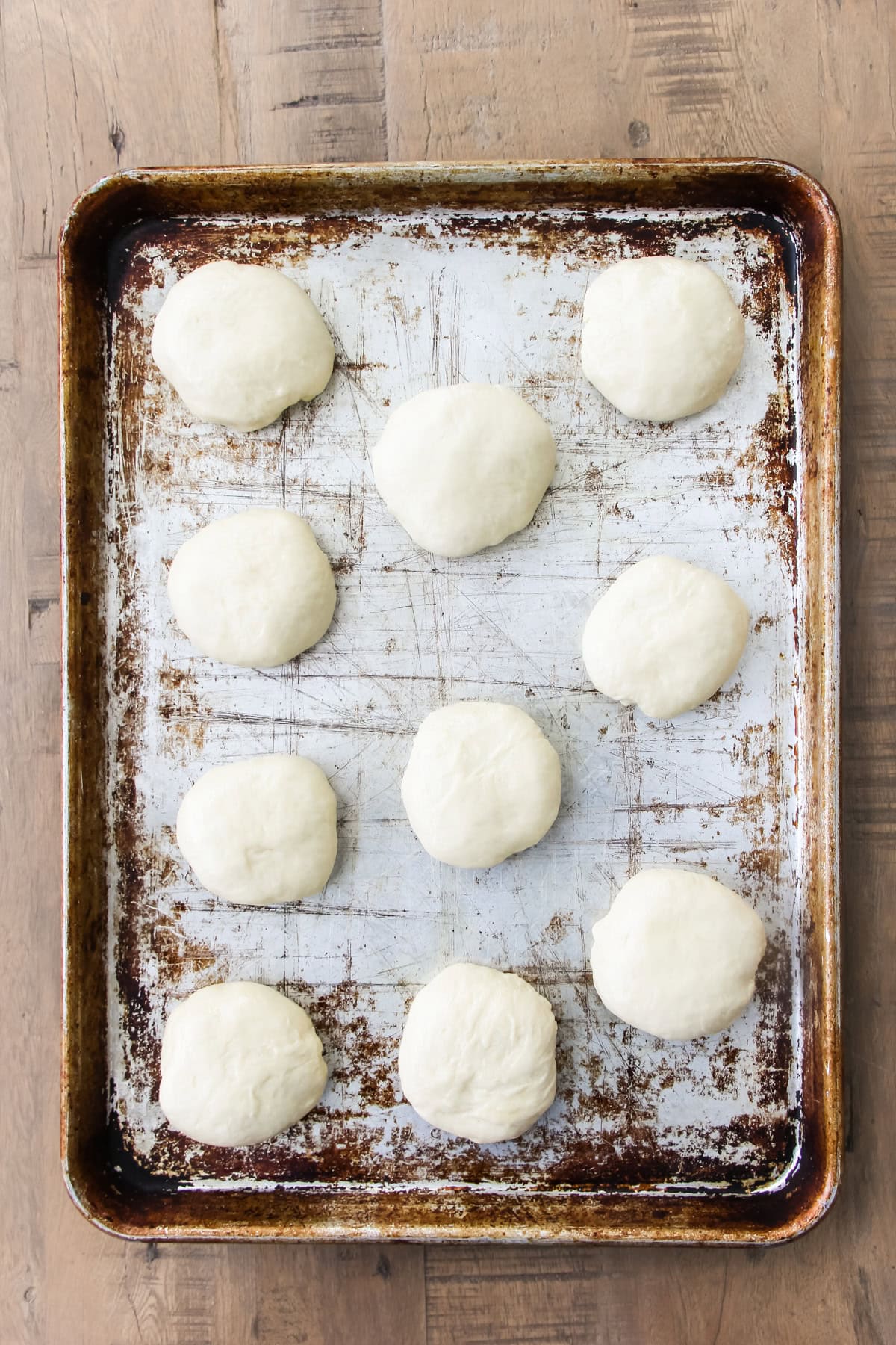 a baking sheet with unbaked homemade hamburger buns