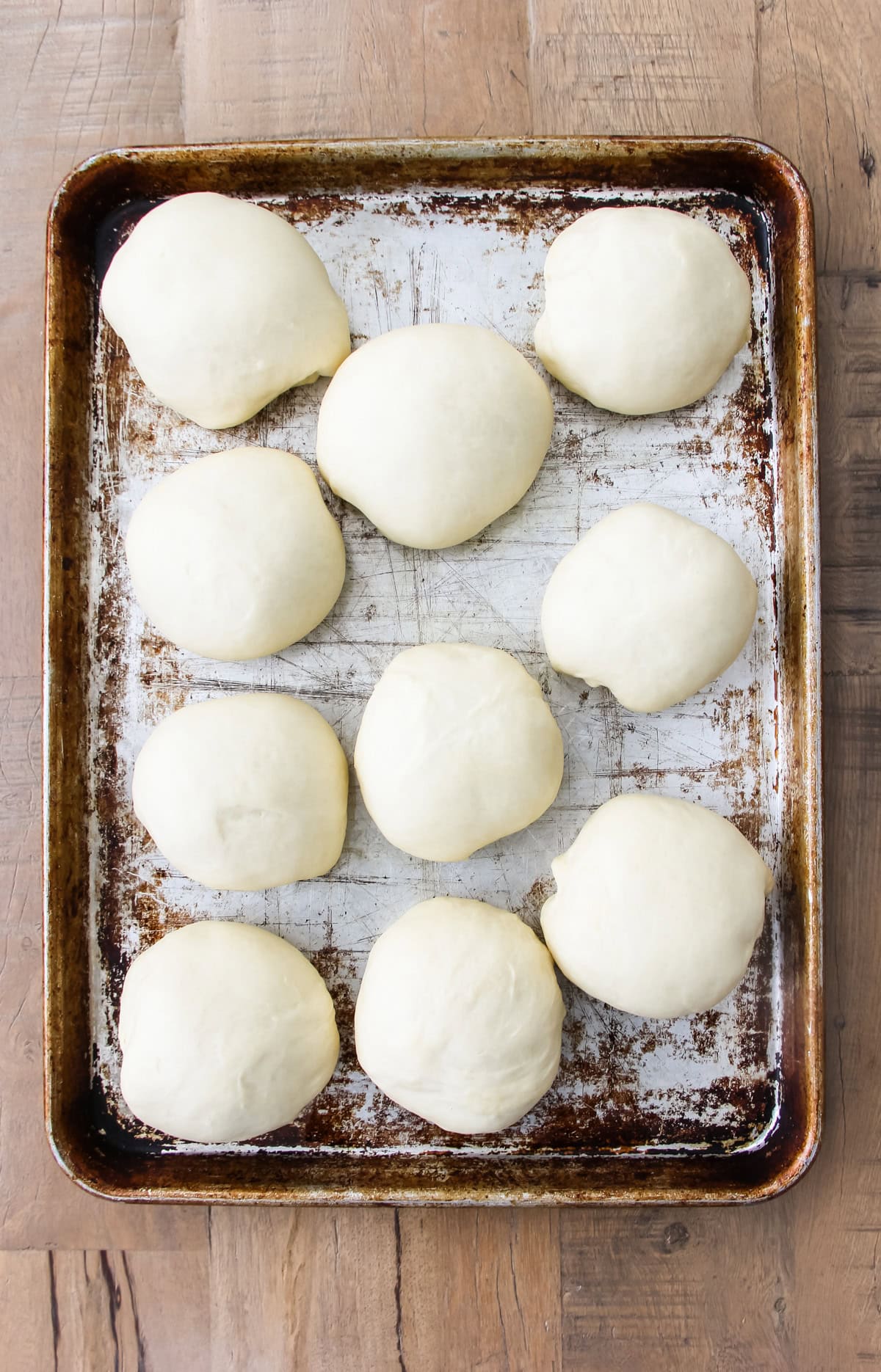 a baking sheet with unbaked homemade hamburger buns