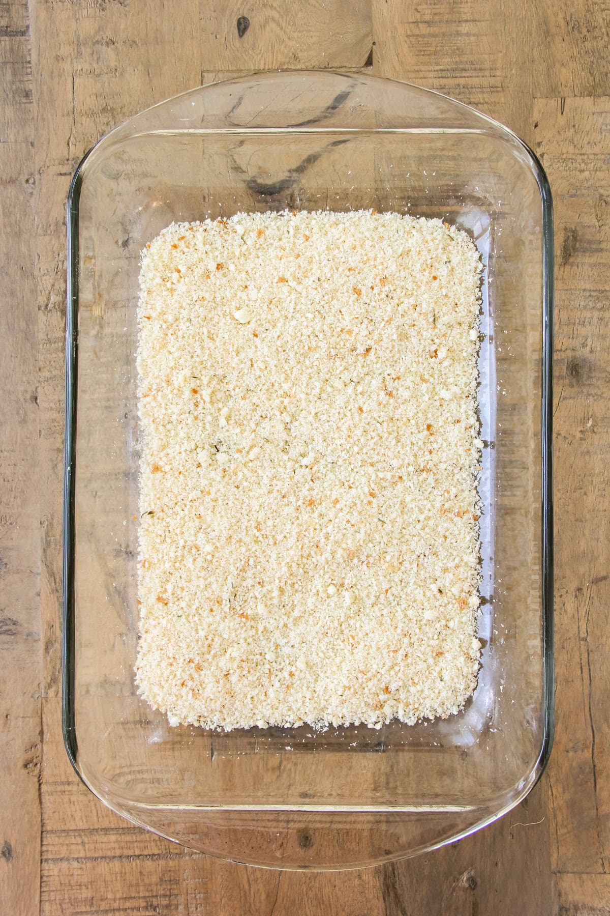 a top down image of a baking pan of unbaked crustless zucchini pie