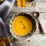 a bowl of roasted squash soup on a wooden table
